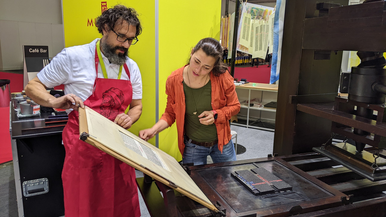 Druckermeister Christoph Sünder mit einer interessierten Besucherin an der rekonstruierten Gutenberg-Presse (c):Gutenberg-Museum, Mainz 