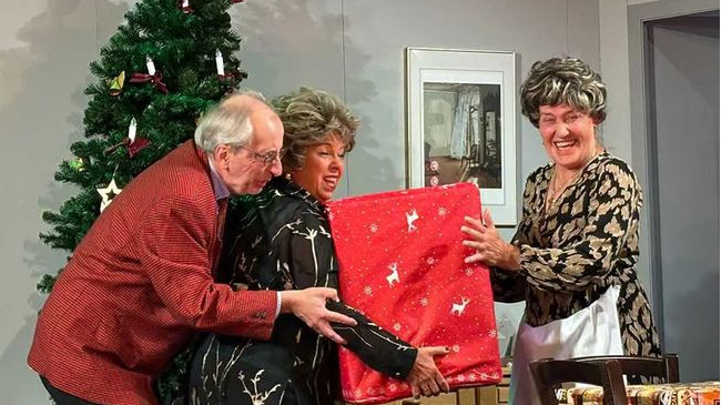 Drei Personen unterm Weihnachtsbaum