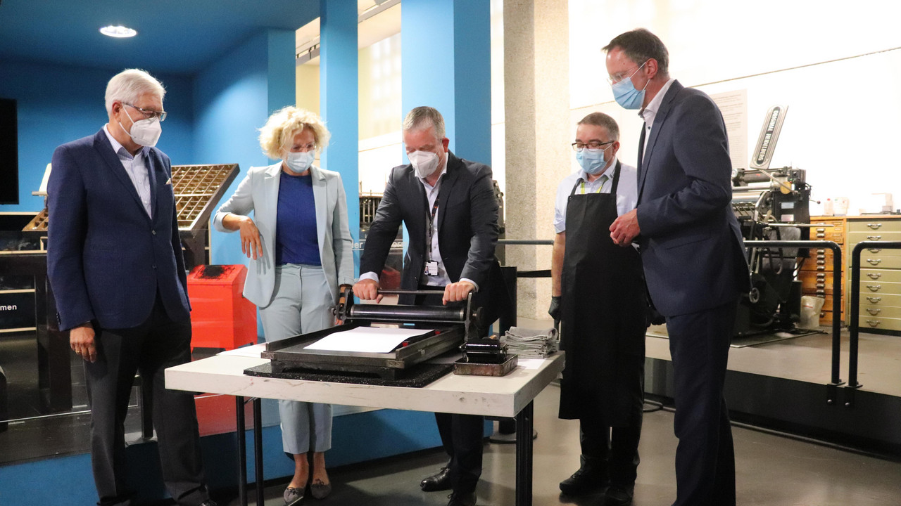 In der Druckwerkstatt druckten die Verantwortlichen der Gutenberg-Gesellschaft, des Gutenberg-Museums und der Stadtwerke auf einer Presse das markante „M“, seit 2016 das Firmenlogo der Mainzer Stadtwerke. V.l.n.r.: Prof. Dr. Stephan Füssel, Dr. Anne
