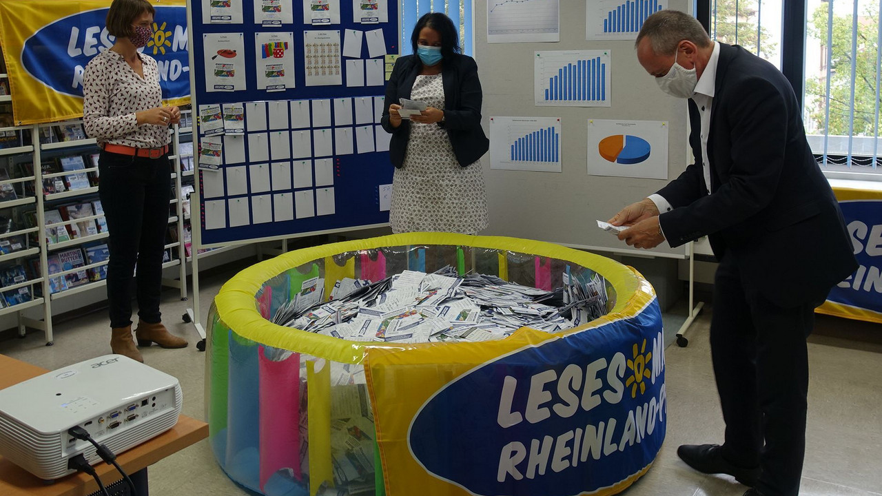 Preisziehung der Preisträger des LESESOMMERS (v.l.n.r.) Kerstin Völker (Landesbibliothekszentrum Rheinland-Pfalz), Giorgina Kazungu-Haß (MdL, Landesvorsitzende Rheinland-Pfalz des Deutschen Bibliotheksverbandes), Kulturminister Prof. Dr. Konrad Wolf. 
