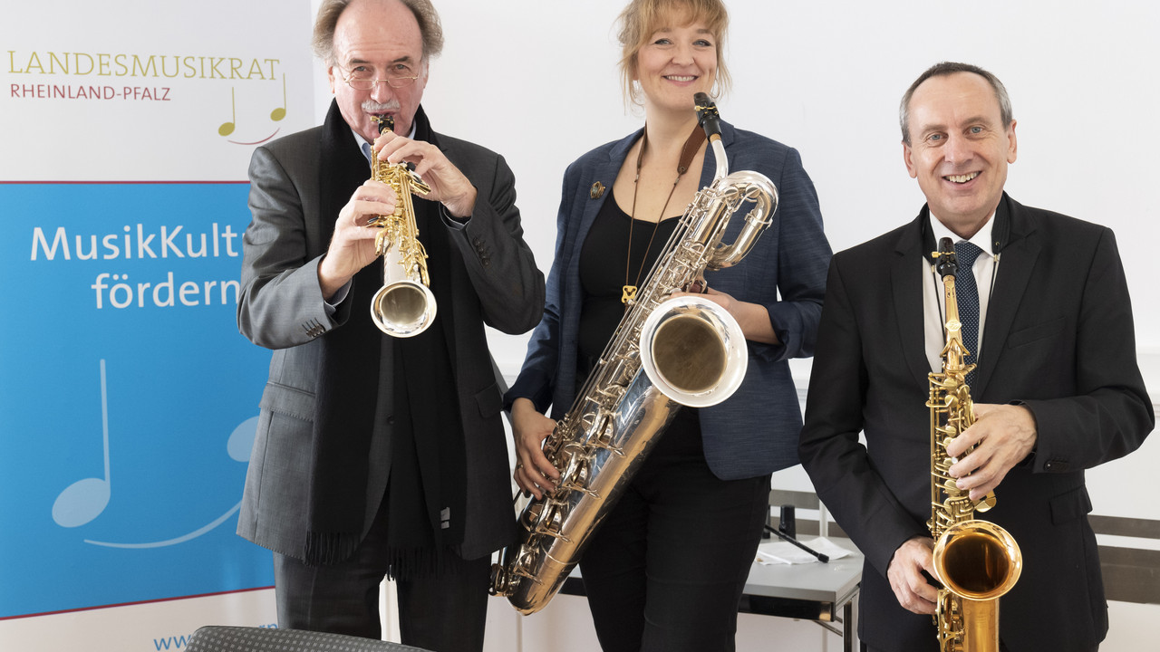 Landesmusikrats-Präsident Peter, Schirmherrin Steph Winzen und Kulturminister Prof. Dr. Konrad Wolf präsentieren das Saxofon als Instrument des Jahres. © Stefan F. Sämmer