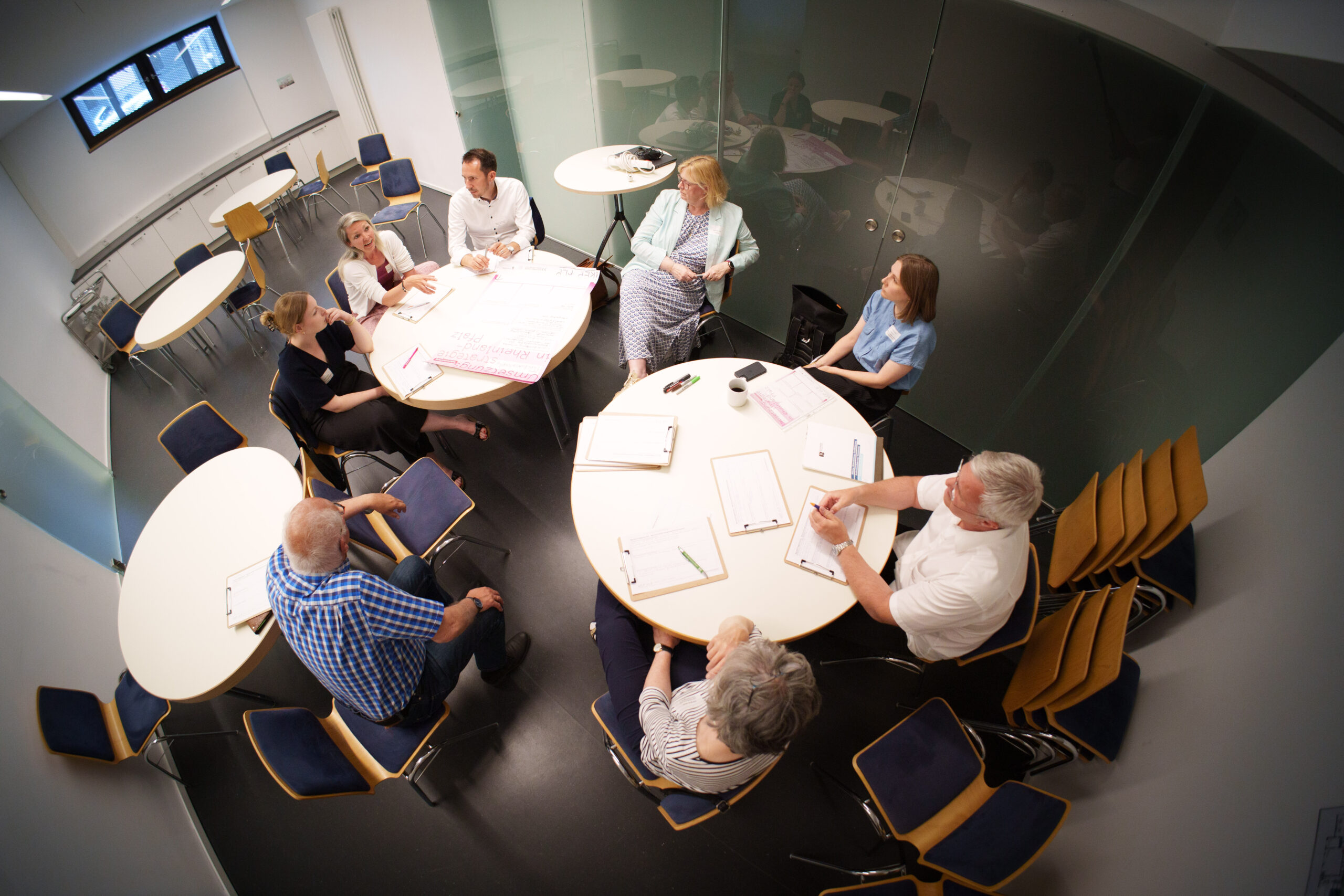 Diskussionsrunde beim vierten Themenforum der Kulturentwicklungsplanung in Rheinland-Pfalz. Man sitzt an runden Tischen und hat Notizen vor sich liegen.